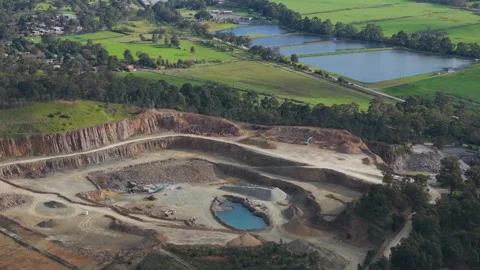 Aerial view of a large open-pit mine and the surrounding green landscape Видео 343621285