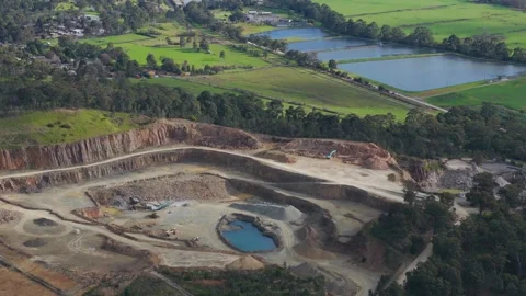 Aerial view of a large open pit mine quarry next to green fields Видео 343621347