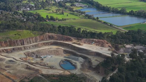 Aerial view of a large open pit quarry next to green fields Видео 343621573