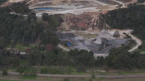 Aerial view of a large open-pit quarry surrounded by forest Видео 343625494