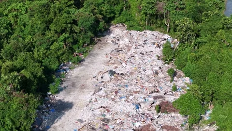 Aerial view of large pile of garbage and waste in forested area pollution Stock Footage 339829856