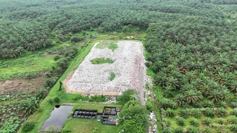 Aerial view of a large pile of trash in a field with green grass. Stock Footage 337016178