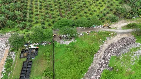 Aerial view of a large pile of trash in a field with green grass. Stock Footage 337016633