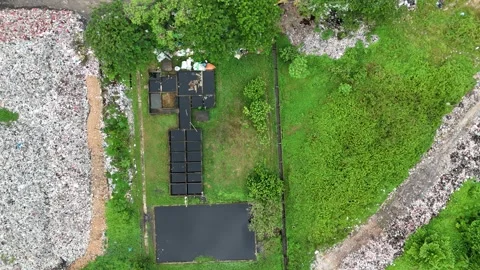 Aerial view of a large pile of trash in a field with green grass. Stock Footage 337016687