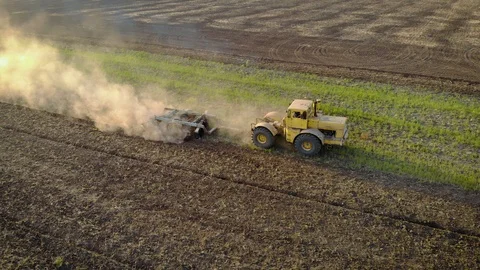Aerial view of large powerful yellow tractor cultivates field with disc plow 스톡 동영상 122329666