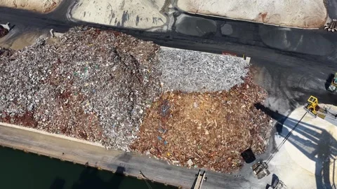 Aerial view of a large recycling facility with vast piles of mixed scrap metal Stock Footage 343569978