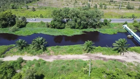 Aerial view of a large river on the edge of a highway, the water looks dark.. Stock Footage 321846295