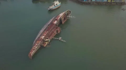 Aerial View of a Large Rusty Shipwreck Capsized in Shallow Sea Water Stockbeeldmateriaal 337101566