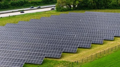 Aerial View of Large Solar Panel Farm Next to Highway Stock Photos