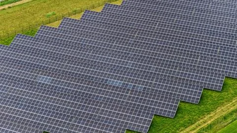 Aerial View of Large Solar Panel Farm in Green Agricultural Field Stock-Fotos