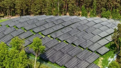 Aerial View of Large Solar Panel Farm in Forest Landscape Stock Photos
