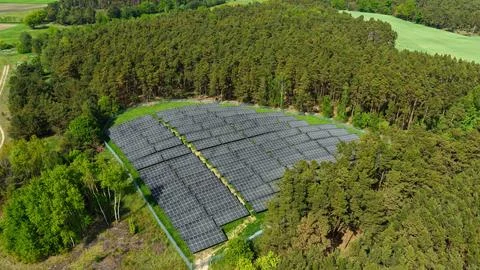 Aerial View of Large Solar Panel Farm in Forest Landscape Foto stock