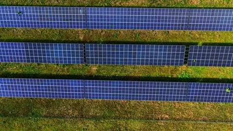 Aerial View of Large Solar Panel Farm in Green Landscape Fotos Stock
