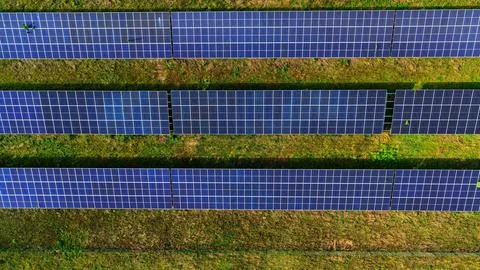 Aerial View of Large Solar Panel Farm in Green Landscape Stock Photos