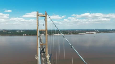 Aerial view of large suspension bridge spanning wide river Vidéo 343523485