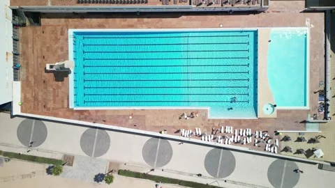 Aerial view of a large swimming pool with sunbathers enjoying a sunny day Stock Footage 284090747