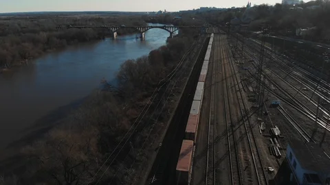 Aerial view of a large train on the rails next to the river. The camera flies Stock Footage 106466542