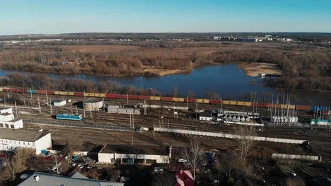 Aerial view of a large train on the rails next to the river. The camera flies up Stock Footage 106472838