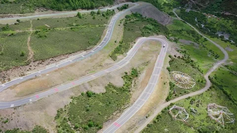 Aerial view of large U-shaped snake highway on barren plateau hills in Daocheng Video stock 336698357