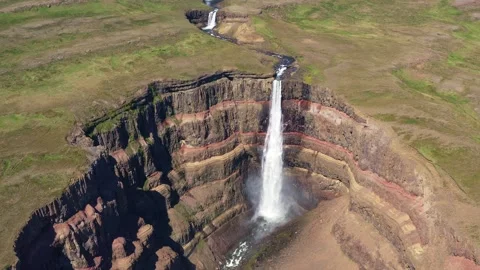 Aerial view of large waterfall over cliffs with uniquely colored layers Video stock 310646006