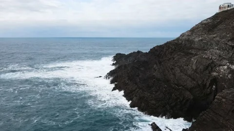 Aerial view of large waves crashing against the rocks at Mizen Head in county Stock Footage 233196332