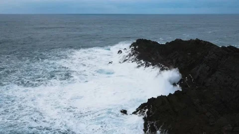 Aerial view of large waves crashing against the rocks at Mizen Head in county Stock Footage 233196697