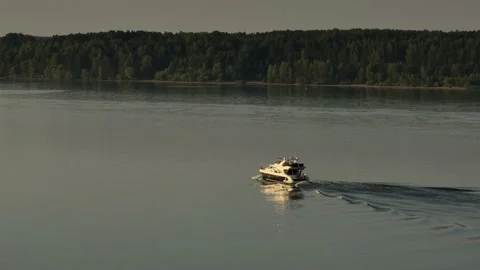 Aerial view. A large white private motor yacht floats on a calm river at sunset. Stock-Footage 234463247