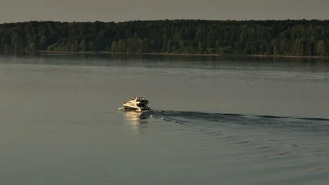 Aerial view. A large white private motor yacht floats on a calm river at sunset. 스톡 동영상 234467110