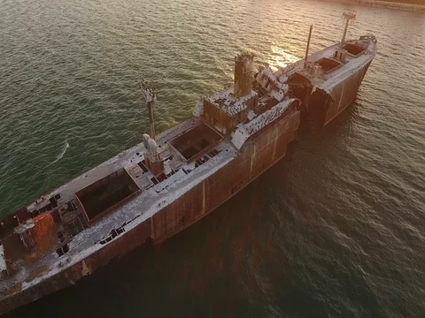 Aerial view of a large wrecked ghost ship in sunset scene Stock Footage 72392070