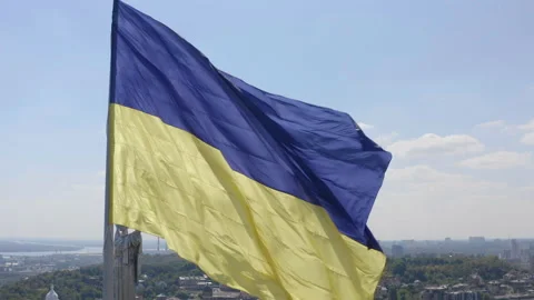 Aerial view of The largest flag of Ukraine is flying against the backdrop of the Stock Footage 202017545