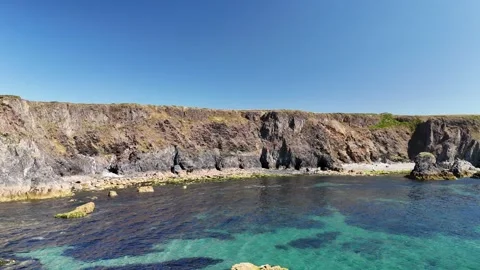 Aerial View of Layered Coastal Cliffs and Clear Water in 4K 動画素材 332943104