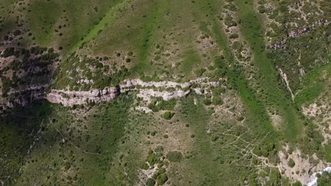 Aerial view of layered rock formations on green mountain slope in Kazakhstan Видео 337194143