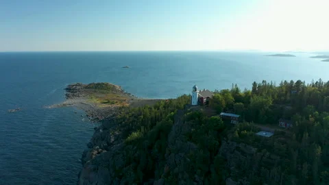 Aerial view of lighthouse high up on a cliff rock Stock Footage 159615426