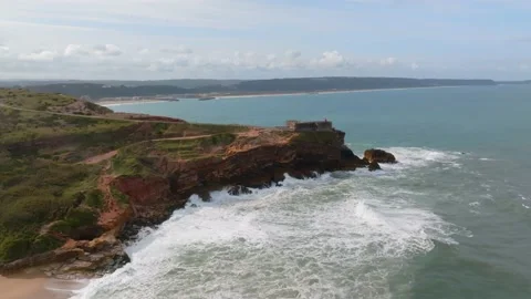 Aerial view of a lighthouse perched on the edge of a cliff at Nazare, Portu.. Stock Footage 239577597