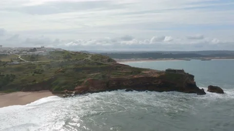 Aerial view of a lighthouse perched on the edge of a cliff at Nazare, Portu.. Stock Footage 239577648