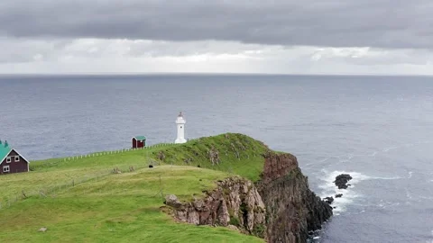 Aerial view of lighthouse on the top of green mountain. Ocean and islands around 動画素材 166201367