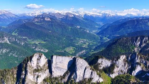 Aerial View of Limestone Cliffs Above Alpine Valley and Snowy Peaks Stock Photos