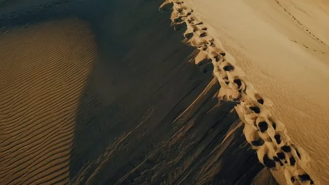 Aerial view on a line of human footprints on sand dunes in a desert. Beautiful Stock Footage 94101484