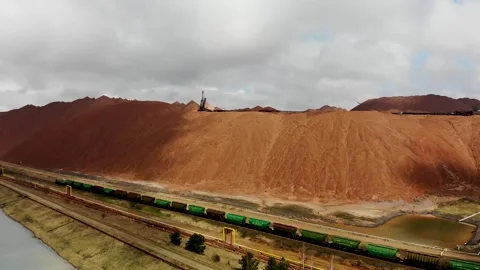 Aerial view of loaded train with potash riding in front of potassium mountains Stock Footage 170552466