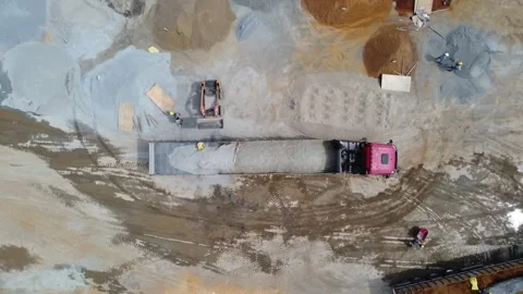 Aerial view of loader pouring sand into truck trailer at construction site Stock Footage 337788598