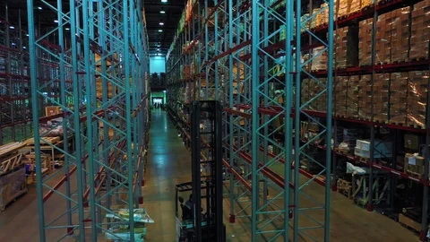 Aerial view of a loader running between giant metal shelves Stock Footage 113091334