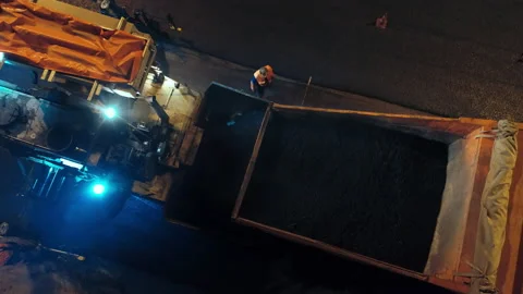 Aerial view. Loading the asphalt concrete mixture into the asphalt paver from a Stock Footage 154217245