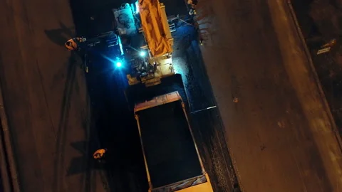 Aerial view loading asphalt mixture into an asphalt paver. Road repair in the Stock Footage 154210868