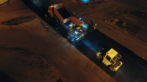 Aerial view loading asphalt mixture into an asphalt paver. Two road rollers are Stock-Footage 154210958