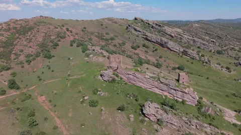 Aerial view of a lone tower ruin on a vast green plain Vídeos de archivo 343325830