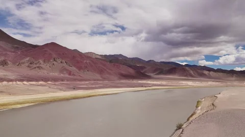 Aerial view of a lonely river crossing vast, lifeless terrain—Ladakh, wild and Stock Footage 310899694
