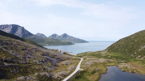 Aerial view of lonely road surrounded by dramatic mountains ocean in Senja Stock Footage 340503382