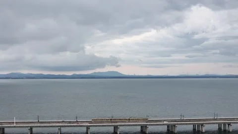 Aerial view of long bridge across lake under gray storm clouds in China Stock Footage 337768018