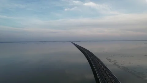 Aerial view of long bridge crossing wide lake at dusk in China Stock Footage 337675909