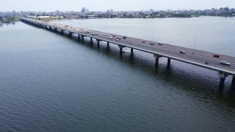 Aerial View of a Long Bridge Spanning a Body of Water with City Skyline. ivory Stock Footage 316190628
